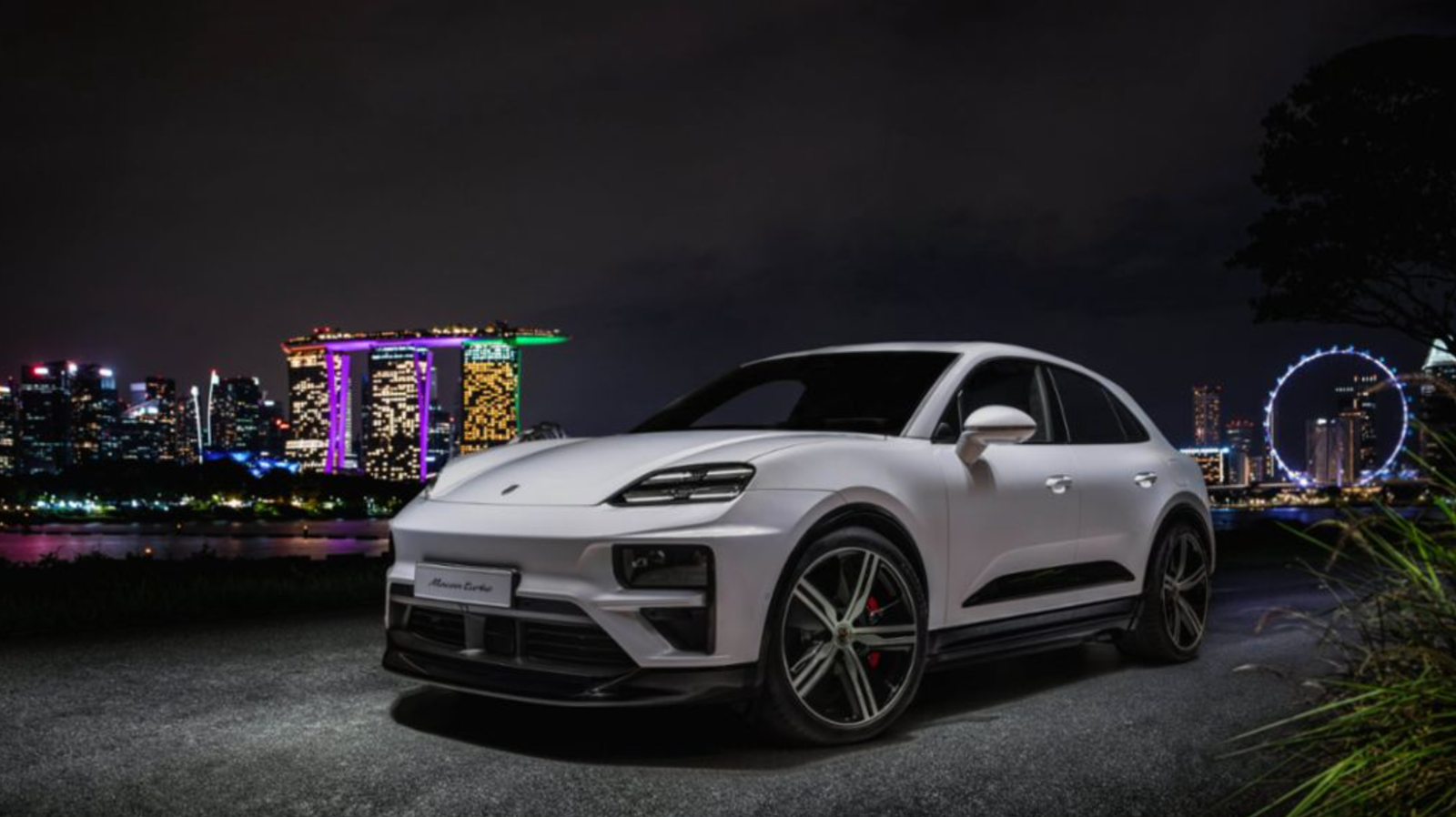 SUV Macan serba listrik dari Porsche menawarkan jangkauan 381 mil dan tenaga hingga 621 hp 3 Eksterior putih dekat kincir ria.