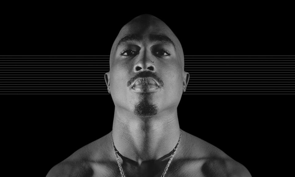 Foto mendiang Tupac Shakur, menatap kamera dengan latar belakang hitam dengan garis abu-abu horizontal halus.