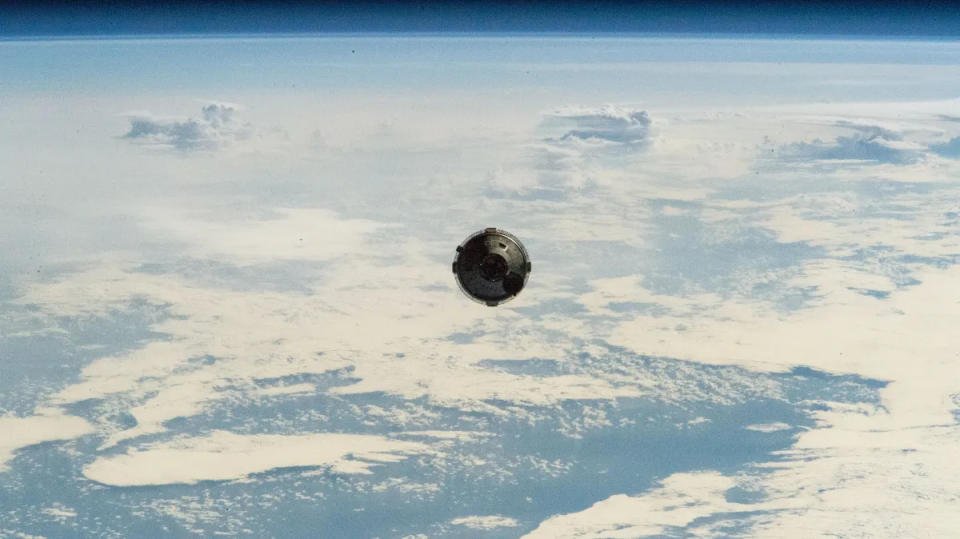 Pemandangan kapsul Boeing Starliner dari ISS mendekat.  Clouded Earth terlihat di belakangnya.