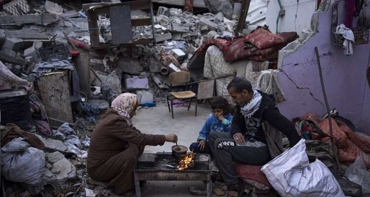 Anggota keluarga Palestina berkumpul di puing puing rumah mereka yang hancur di kota Rafah Jalur Gaz