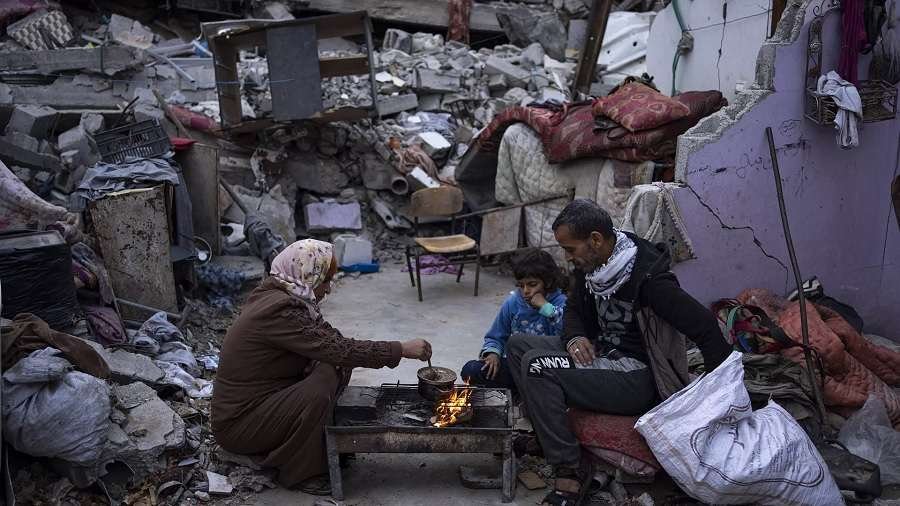 Anggota keluarga Palestina berkumpul di puing puing rumah mereka yang hancur di kota Rafah Jalur Gaz